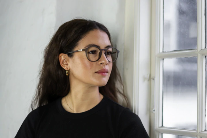 Brillemode - En kvinde bærer moderne runde briller i mørk farve